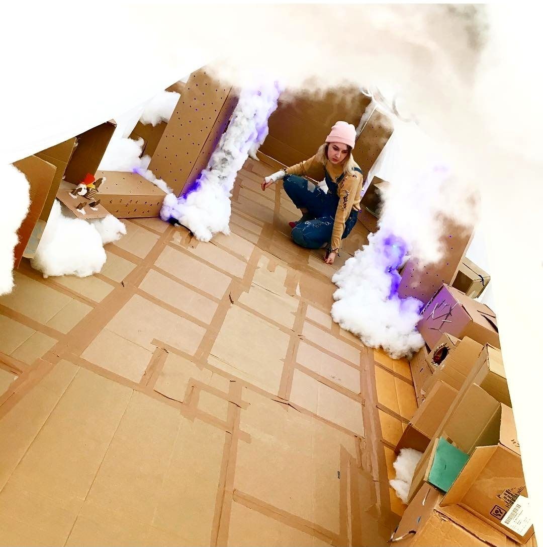 Inside the cardboard cloud room with cotton-wool clouds and purple light