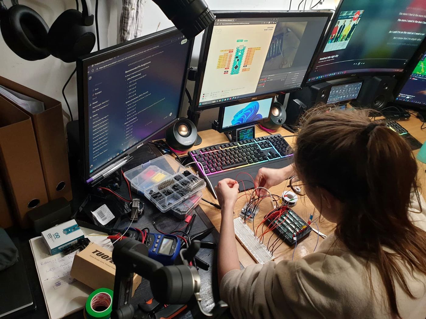 Workbench with breadboard, wires and screens while a circuit is being built