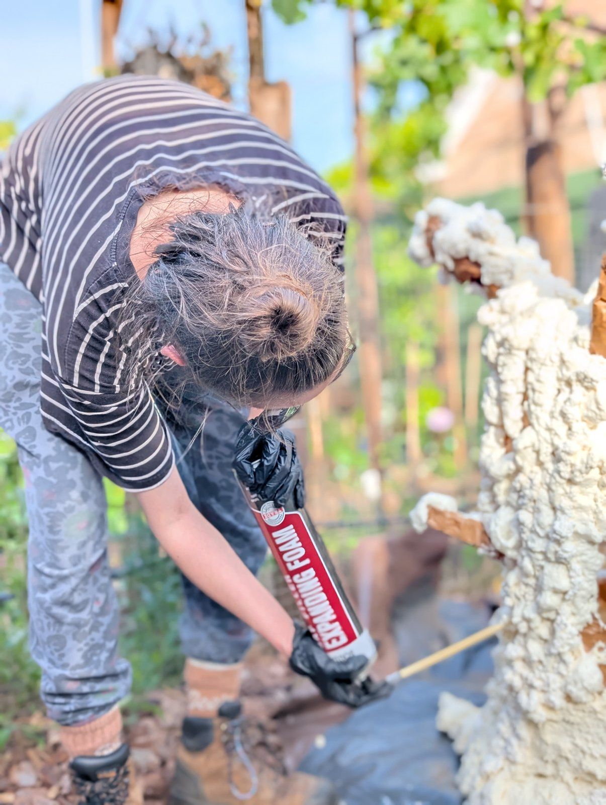 Spraying the foam on, one can at a time.